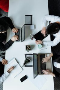 4 personnes se trouve sur un bureau et travaillent ensemble